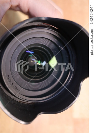 Close-up of Camera Lens with Hand Holding Close-up of Camera Lens with Hand Holding 142434244