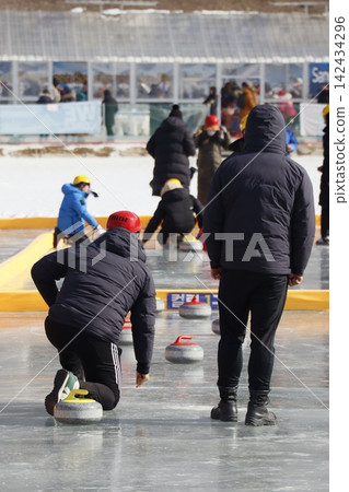 Curlers Competing on Ice Rink Curlers Competing on Ice Rink 142434296