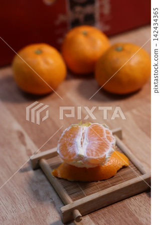 Fresh Peeled Orange and Whole Oranges on Wooden Surface Fresh Peeled Orange and Whole Oranges on Wooden Surface 142434365
