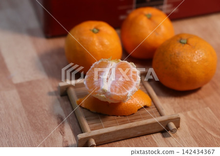 Fresh Peeled Orange with Whole Oranges on Wooden Tray Fresh Peeled Orange with Whole Oranges on Wooden Tray 142434367