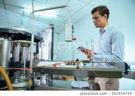 Focused male engineer using digital tablet on factory production line Focused male engineer using digital tablet on factory production line 142434734