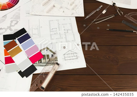 Architectural drawings and color swatches on wooden table 142435035