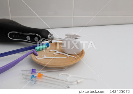 From minimal to expanded dental care: tools on a wooden tray in a home bathroom From minimal to expanded dental care: tools on a wooden tray in a home bathroom 142435073