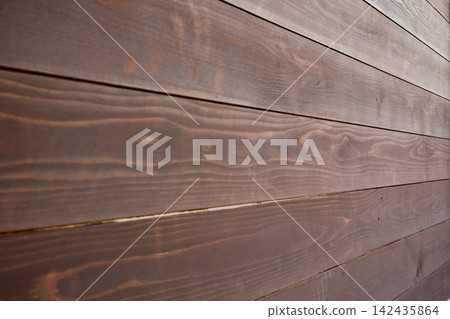 A dark brown wooden wall in a diagonal composition that highlights the sense of depth and smooth bokeh. The focus is on the background. 142435864
