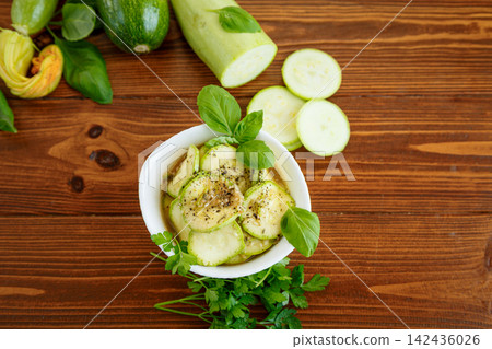 Homemade zucchini appetizer with garlic herbs on rustic wood background Homemade zucchini appetizer with garlic herbs on rustic wood background 142436026