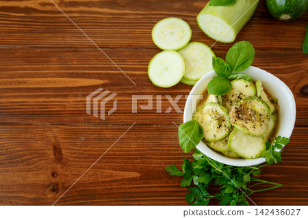 Homemade zucchini appetizer with garlic herbs on rustic wood background Homemade zucchini appetizer with garlic herbs on rustic wood background 142436027