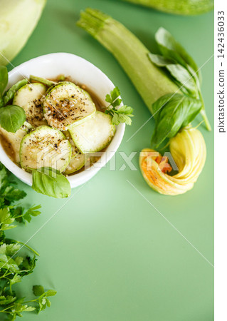 Homemade marinated zucchini slices with garlic on green background Homemade marinated zucchini slices with garlic on green background 142436033