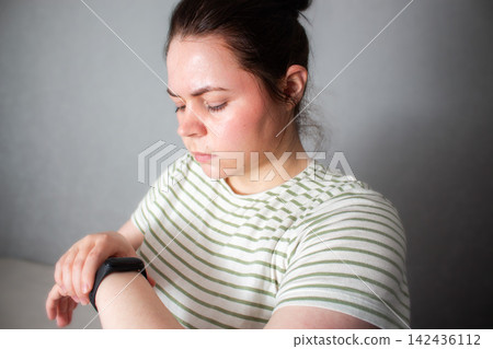 Woman checks health indicators using tracking app on smartwatch. Smart health means using devices as assistants not overlords. Low alarm high-awareness living. Digital detox concept Woman checks health indicators using tracking app on smartwatch. Smart health means using devices as assistants not overlords. Low alarm high-awareness living. Digital detox concept 142436112