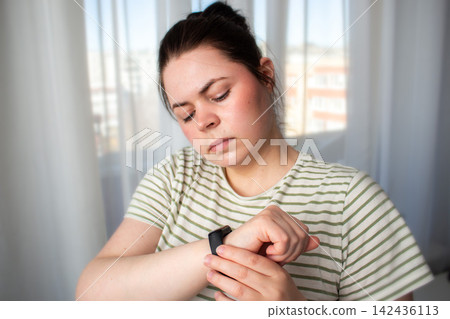 Morning light, glass of water and human uses smartwatch to track health. Pulse visible but not demanding attention. Digital detox mindset: tools assist, but life happens off-screen Morning light, glass of water and human uses smartwatch to track health. Pulse visible but not demanding attention. Digital detox mindset: tools assist, but life happens off-screen 142436113