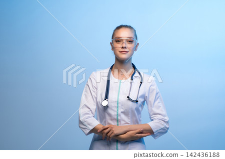 Female doctor wearing safety goggles and stethoscope Female doctor wearing safety goggles and stethoscope 142436188