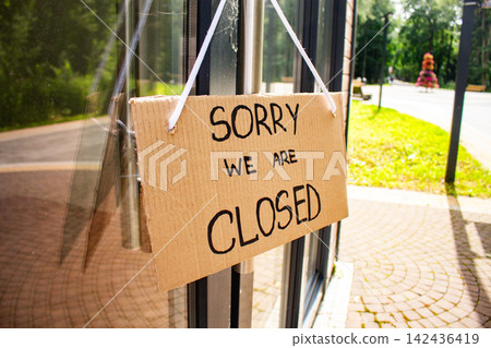 Sign SORRY WE ARE CLOSED on welcome door of small shop. Local business closure. Owners facing economic struggles and client loss 142436419
