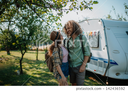 Young couple is on a camping trip in nature. Budget friendly caravan travel. Young couple is on a camping trip in nature. Budget friendly caravan travel. 142436592