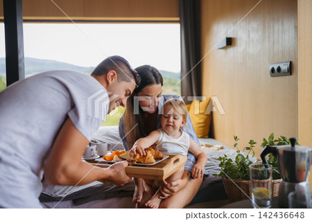 Young woman with husband and baby indoors, weekend away in small cotage n countryside. Young woman with husband and baby indoors, weekend away in small cotage n countryside. 142436648