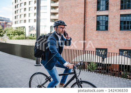 City commuter riding bike to office, wearing backpack and helmet. City commuter riding bike to office, wearing backpack and helmet. 142436830