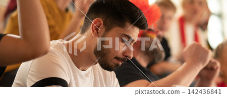 Worried football fans supporting German national team in live soccer match at stadium. Worried football fans supporting German national team in live soccer match at stadium. 142436841
