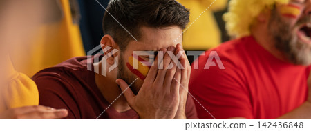 Worried football fans supporting spanish national team in live soccer match at stadium. Worried football fans supporting spanish national team in live soccer match at stadium. 142436848