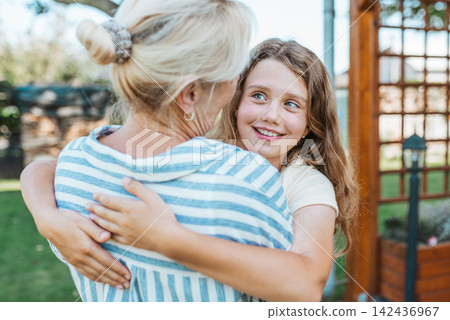 Grandmother and granddaughter hugging in the garden. Grandmother and granddaughter hugging in the garden. 142436967