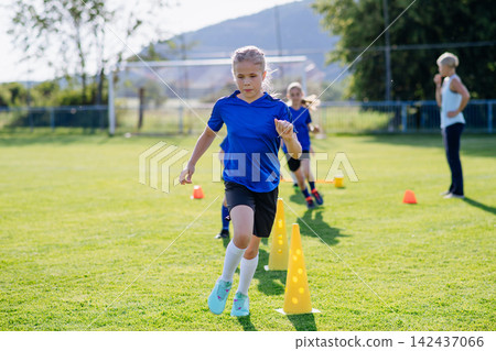 Children practicing speed and coordination drills during football training. Children practicing speed and coordination drills during football training. 142437066