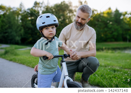 Father and son enjoying bike riding in park. Father and son enjoying bike riding in park. 142437148