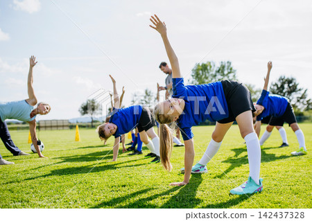 Young football players warming up before training session on pitch. Young football players warming up before training session on pitch. 142437328