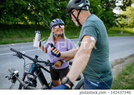 Active seniors with diabetes preparing for electric bike trip. Active seniors with diabetes preparing for electric bike trip. 142437346