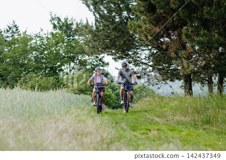 Active senior couple exploring nature on electric bicycles Active senior couple exploring nature on electric bicycles 142437349