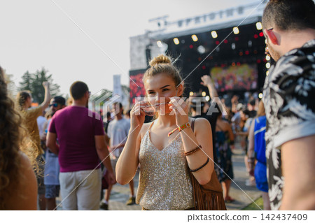 Young woman enjoying summer festival. Young woman enjoying summer festival. 142437409