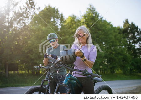 Active senior couple preparing for electric bike trip. 142437466