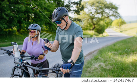 Active senior couple preparing for electric bike trip. 142437467