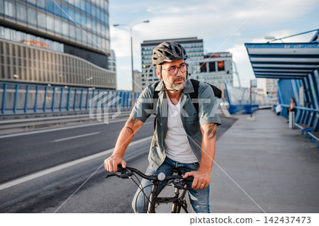 Male cyclist riding bike down the street. Male cyclist riding bike down the street. 142437473