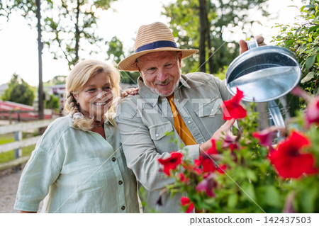 Happy elderly couple enjoying gardening in countryside. Happy elderly couple enjoying gardening in countryside. 142437503