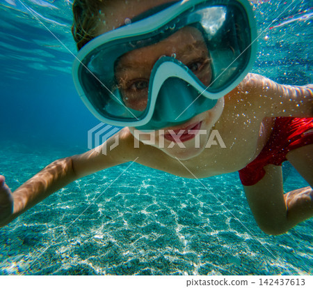 Child snorkeling underwater in tropical sea during family summer vacation. 142437613