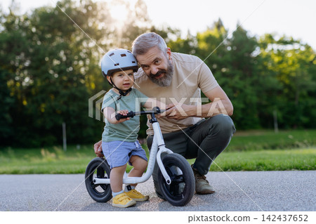 Father and son enjoying bike riding in park. Father and son enjoying bike riding in park. 142437652