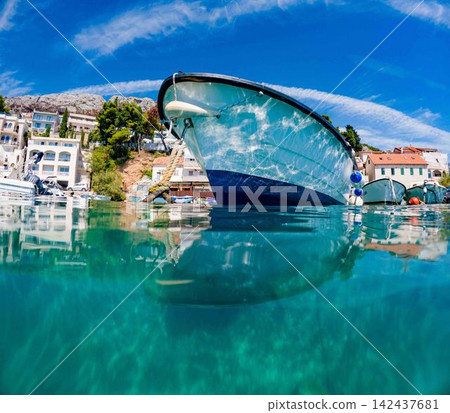 Traditional fishing boat floating in crystal clear Adriatic Sea in coastal village of Dalmatia, Croatia. Traditional fishing boat floating in crystal clear Adriatic Sea in coastal village of Dalmatia, Croatia. 142437681