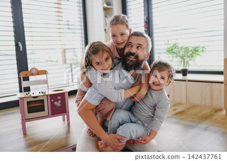 Playful father enjoying family time with his daughters at home. Playful father enjoying family time with his daughters at home. 142437761