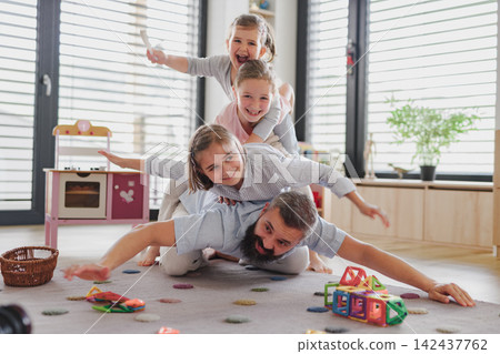 Dad playing with his daughters during a fun day at home. Dad playing with his daughters during a fun day at home. 142437762
