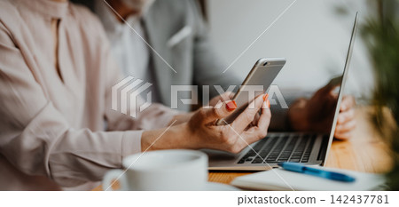 Close up of woman in coffe shop, holding smartphone and making reservation. Close up of woman in coffe shop, holding smartphone and making reservation. 142437781