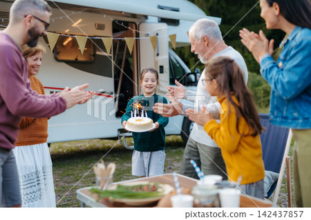 Multigenerational family celebrating girls birthday during camper vacation. Multigenerational family celebrating girls birthday during camper vacation. 142437857