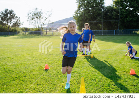 Young athletes training footwork and coordination on soccer field. Young athletes training footwork and coordination on soccer field. 142437925