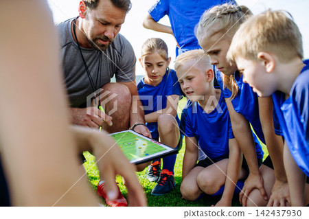 Coaches giving tactical instructions to a youth soccer team during practice. Coaches giving tactical instructions to a youth soccer team during practice. 142437930
