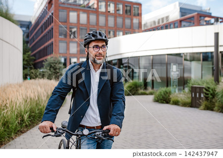 Male cyclist riding bike down the street. Male cyclist riding bike down the street. 142437947