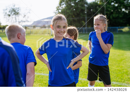 Mixed youth football team standing together on soccer field before training. 142438026