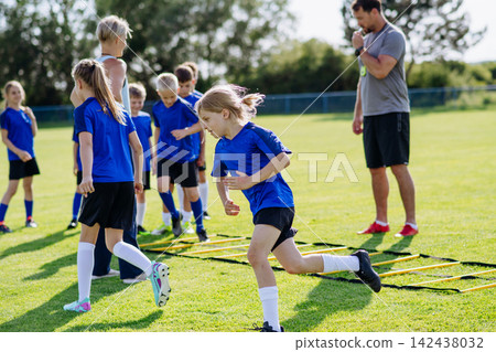 Young soccer players practicing agility ladder drills during training Young soccer players practicing agility ladder drills during training 142438032