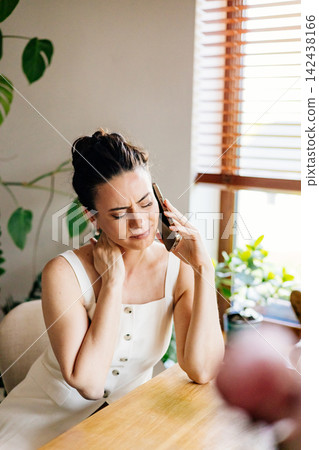Confident woman sitting on sofa and making phone call. Confident woman sitting on sofa and making phone call. 142438166