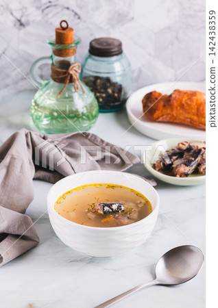 Simple budget soup with canned sardines and vegetables in a bowl on the table vertical view Simple budget soup with canned sardines and vegetables in a bowl on the table vertical view 142438359