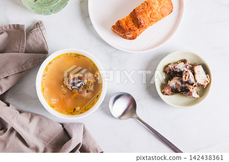 Simple budget soup with canned sardines and vegetables in a bowl on the table top view Simple budget soup with canned sardines and vegetables in a bowl on the table top view 142438361
