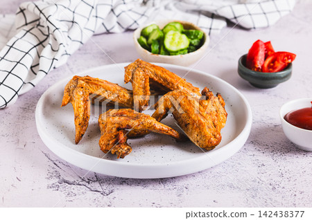 Crispy chicken wings baked in an air fryer on a plate on the table Crispy chicken wings baked in an air fryer on a plate on the table 142438377
