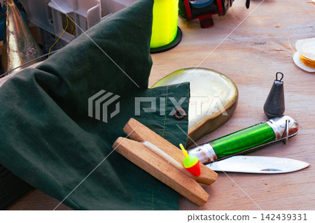 Fishing equipment close up with various tackle items, including lines, bobbers, and a reel, ready for a relaxing outdoor fishing trip. Fishing equipment close up with various tackle items, including lines, bobbers, and a reel, ready for a relaxing outdoor fishing trip. 142439331