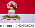 A photograph with a "kagami mochi" (rice cake offering) placed on the left, against a red and white background, without a sanbo (stand). 142439522