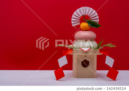 照片中,一個真正的紅白相間的米餅(「鏡餅」)放在右邊,背景是紅白相間,旁邊還附有一個三寶(支架)。 照片中,一個真正的紅白相間的米餅(「鏡餅」)放在右邊,背景是紅白相間,旁邊還附有一個三寶(支架)。 142439524